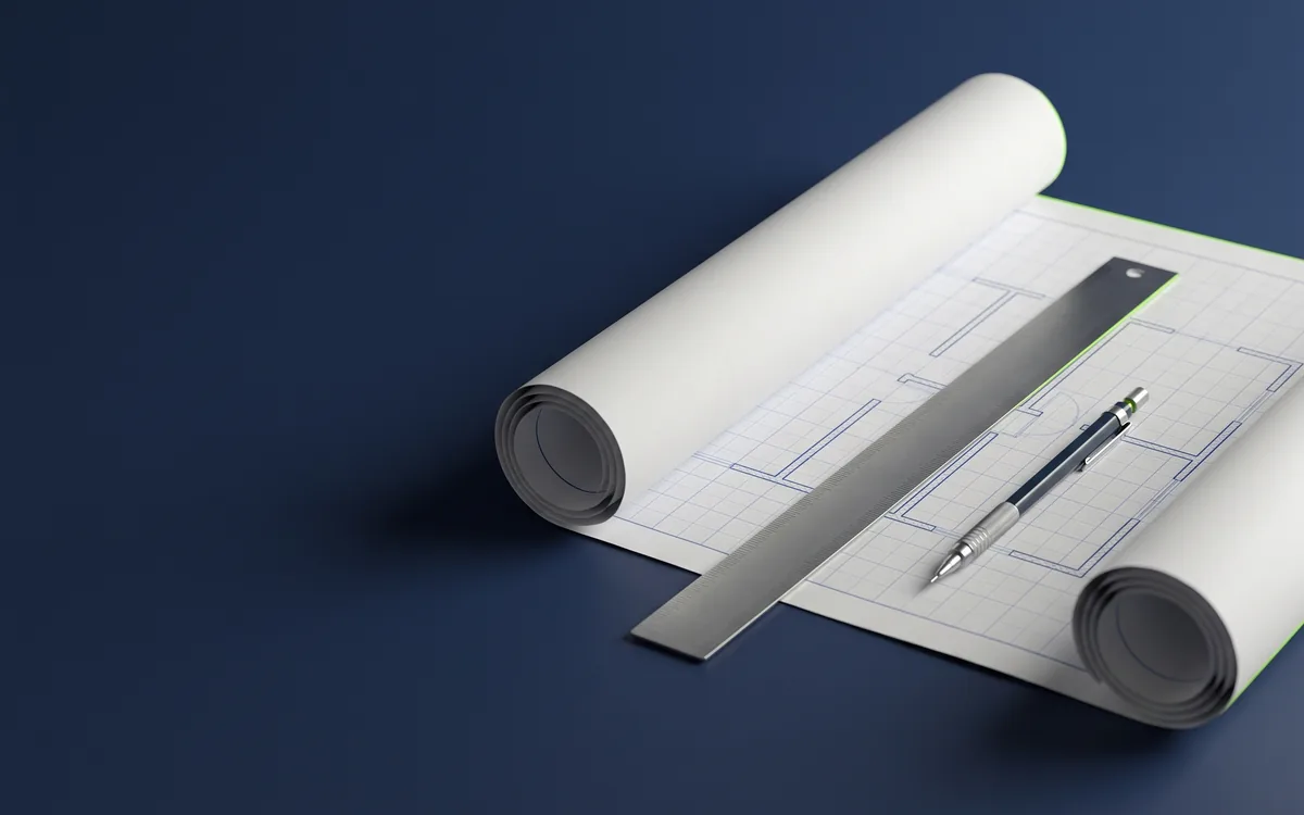 Illustration: a partly unrolled sheet of drafting paper showing blank wall outlines on a faint grid, with a steel straightedge and a mechanical pencil laid across it.