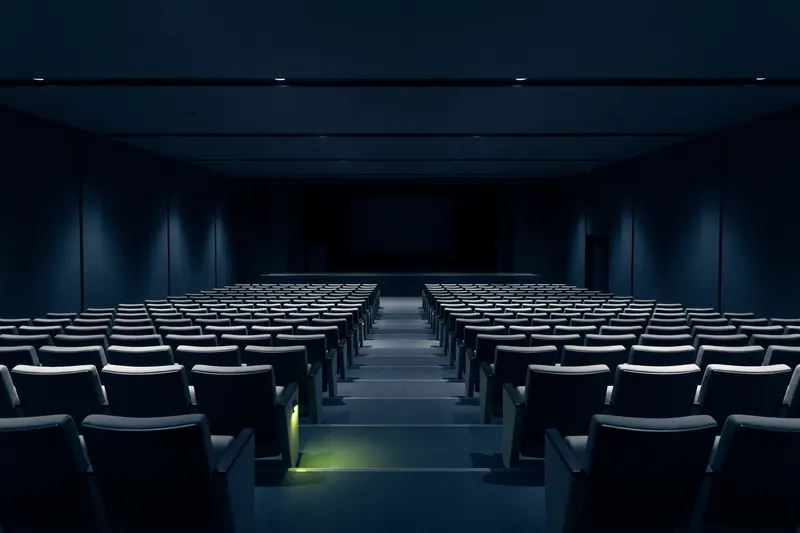 Illustration: an empty conference hall with rows of seats facing a dark stage, a single lime aisle light.